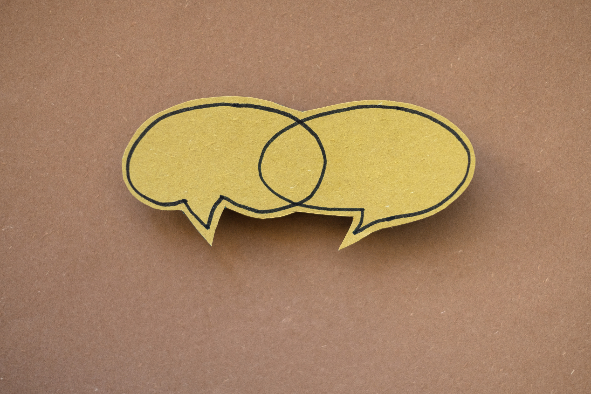 Stimmungsbild: Zwei Sprechblasen, aus Papier ausgeschnitten.