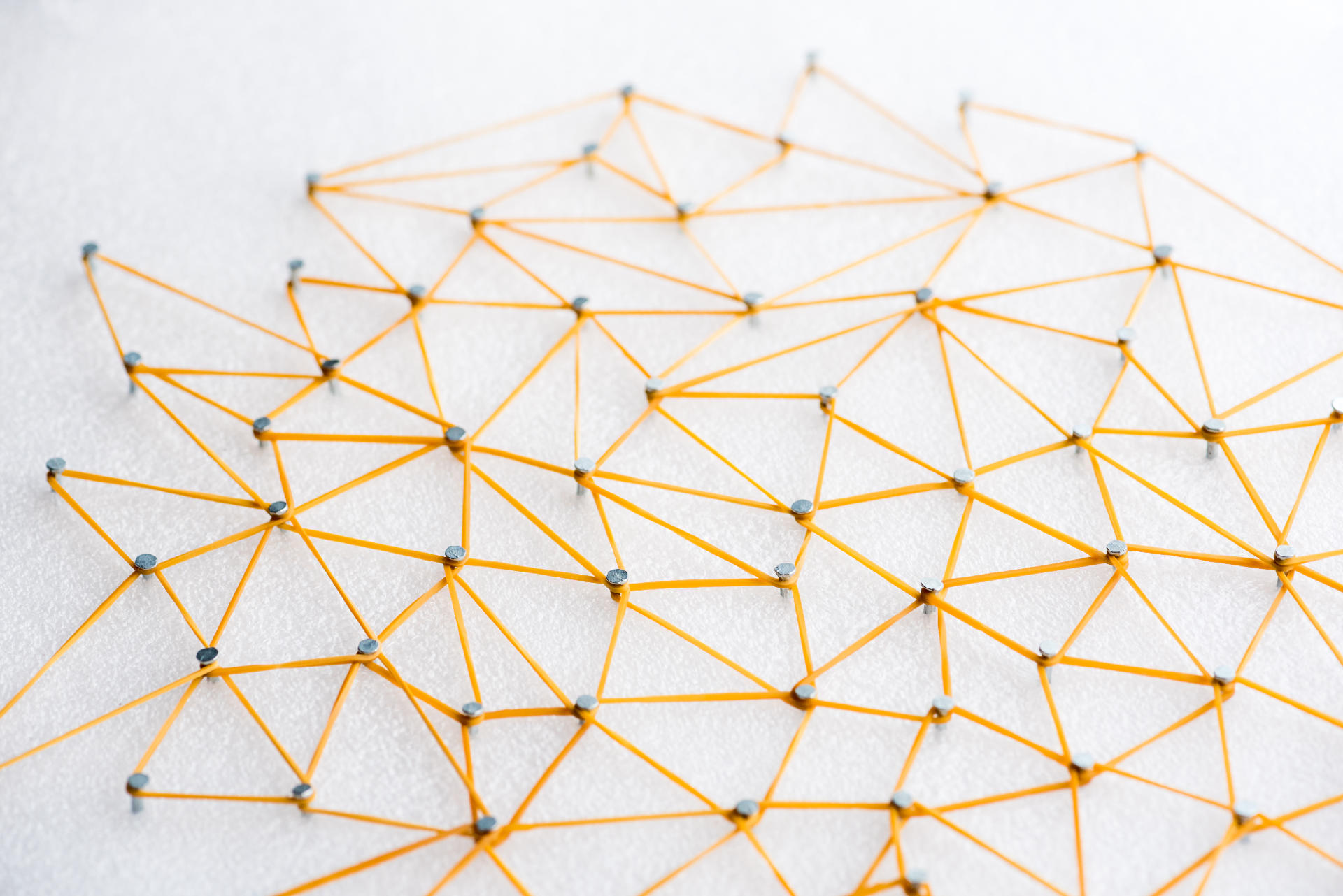 Stimmungsbild mit Gummibändern die um verschiedene Nägel gespannt sind.